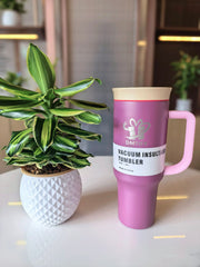 Lilac vacuum insulated tumbler with a plant on a table