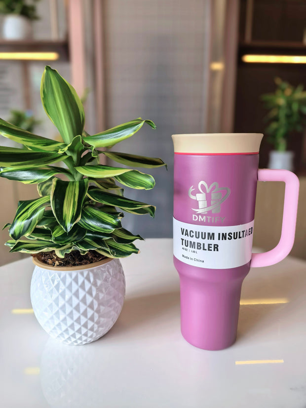 Lilac vacuum insulated tumbler with a plant on a table