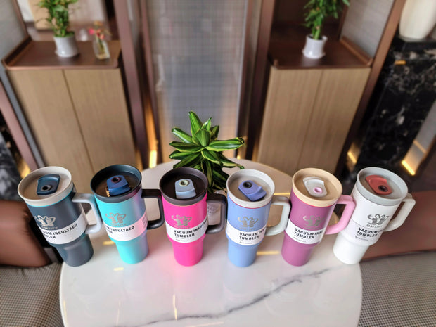 Set of colorful mugs with a brand logo on a marble surface.