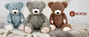 Three teddy bears in blue, gray, and brown sitting on a textured surface with 'Boyd's' logo.