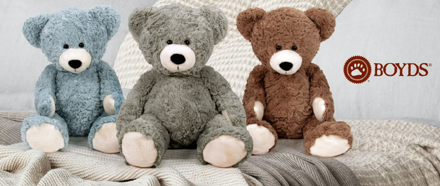 Three teddy bears in blue, gray, and brown sitting on a textured surface with 'Boyd's' logo.