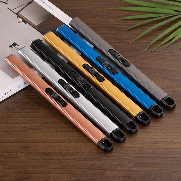 Five USB Candle lighters  in different colours on a wooden surface with a magazine and plant in the background.