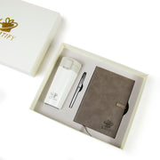Gift set with a notebook, pen, and white bottle in a branded box.