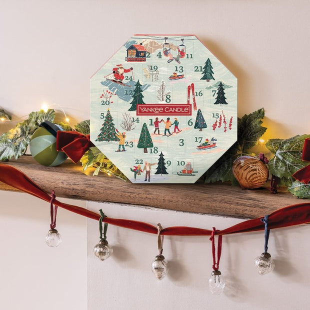 Yankee Candle advent calendar on a decorative shelf with Christmas decorations.