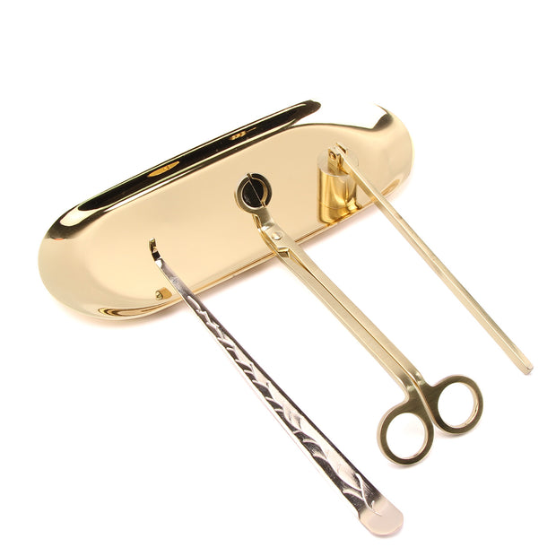 Gold set of candle care tools on a white background.